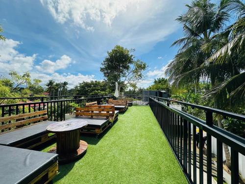 a row of benches on a balcony with grass at Pig Dive Hostel Moalboal in Moalboal