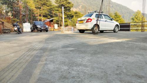 a white car parked on the side of a road at Paradiso Guest House in McLeod Ganj