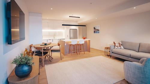 a living room and kitchen with a couch and a table at Beautiful urban apartment 4 in Nelson