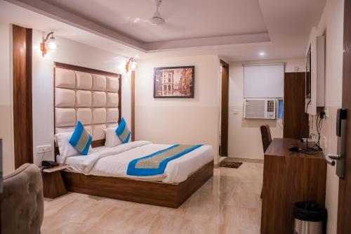 a bedroom with a bed with blue pillows in it at Hotel Airport City Near Delhi International Airport in New Delhi