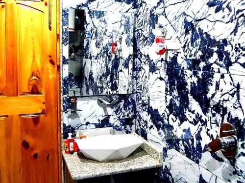 uma casa de banho com um lavatório branco e uma parede em mármore em Waneposh Residency em Srinagar