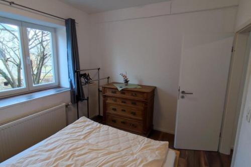 a bedroom with a bed and a window and a dresser at FeWo Alsfeld / Vogelsberg 1 mit extra Eingang in Alsfeld