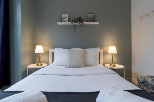 a bedroom with a large white bed with two lamps at Hypercentre - 2 pièces confortable in Lille