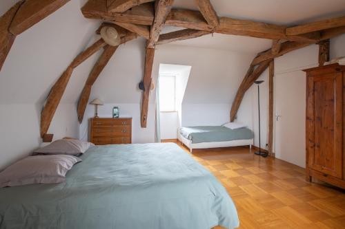 1 dormitorio con 1 cama grande con vigas de madera en La Belonnerie - Grande maison pour 13, en Varrains