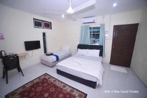 a bedroom with a bed and a couch and a tv at Bee Good Chalet in Yan