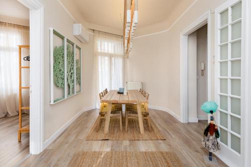 una sala da pranzo con tavolo e sedie in legno di Margarita by halu!, 3-BD tropical house a Salonicco