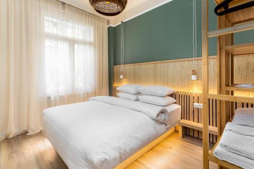 una camera da letto con letto, lenzuola e cuscini bianchi di Margarita by halu!, 3-BD tropical house a Salonicco