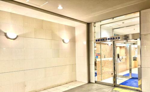 a store front with a glass door with a sign on it at Toyoko Inn Kyoto Shijo-omiya in Kyoto