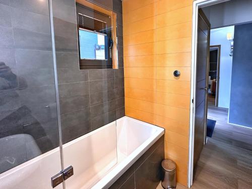 a bathroom with a tub and a glass shower at Chy Cos. South facing lodge with balcony & views. in St. Agnes 
