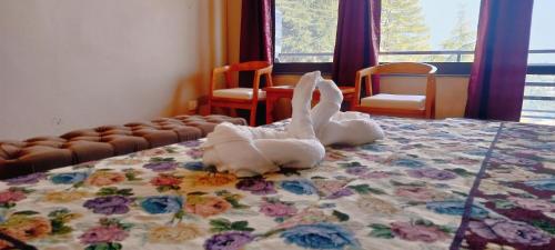 a stuffed rabbit sitting on top of a bed at Paradiso Guest House in McLeod Ganj
