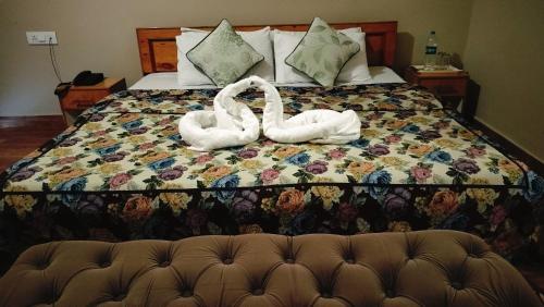 two swans sitting on top of a bed at Paradiso Guest House in McLeod Ganj