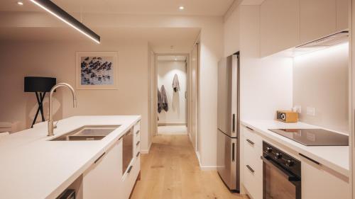 eine Küche mit weißen Arbeitsplatten und einem Flur in der Unterkunft Beautiful urban apartment 5 in Nelson