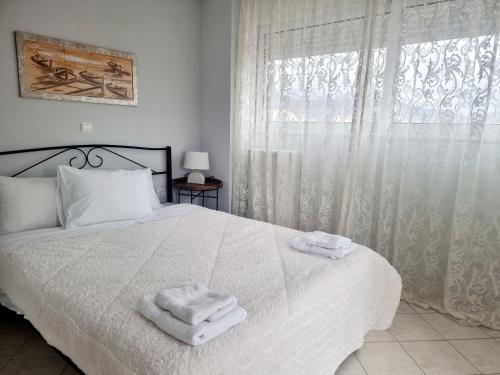 a bedroom with a white bed with towels on it at inspire tripoli in Tripoli