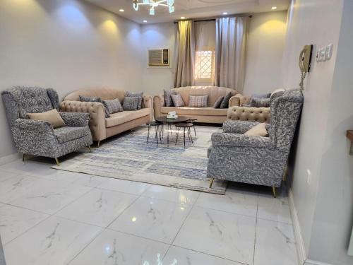 a living room with two couches and a table in it at شقة عائلية فخمة in Al Madinah
