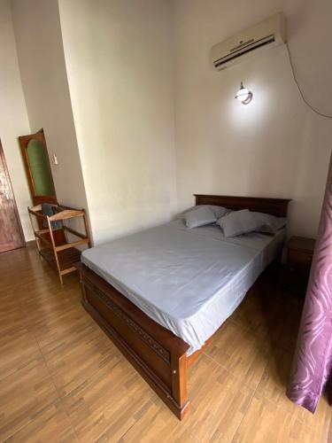 a bedroom with a bed in a room with a chair at The Serene House in Negombo