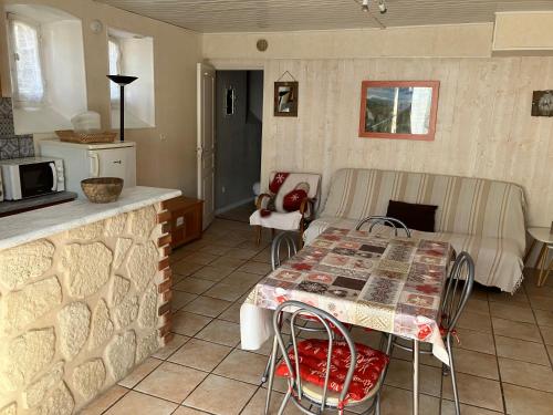 a living room with a table and a kitchen at Le Mont Dore Résidence Cottage rez de chausse in Le Mont-Dore