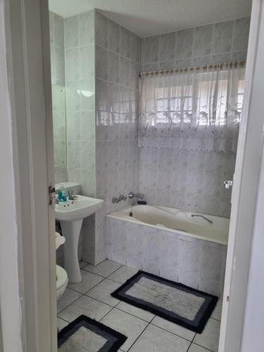 a bathroom with a tub and a toilet and a sink at Stella Maris 117 Amanzimtoti in Amanzimtoti