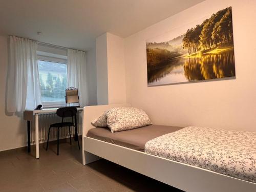 um quarto com uma cama, uma secretária e uma janela em db-rooms-b em Kassel