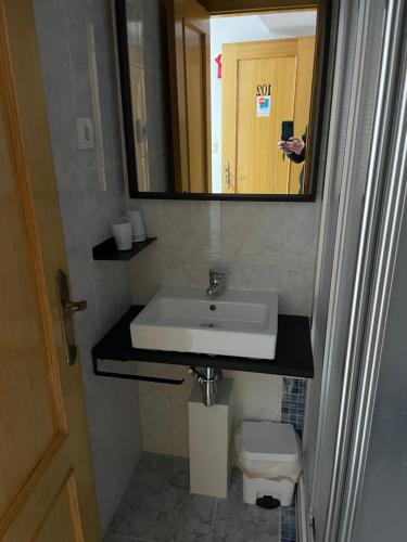 a bathroom with a sink and a mirror and a toilet at Albahicín in Puerto de Sagunto