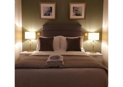 a bedroom with a large bed with two lamps at Station Lodge in Sligo