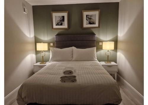 a bedroom with a large bed with two lamps at Station Lodge in Sligo