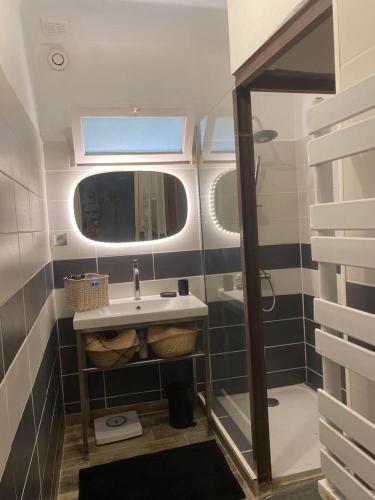 une salle de bain avec un lavabo et un miroir dans l'établissement MAISON PLEIN SUD SUR LES TOITS au 2 terrasses, à Montagnac