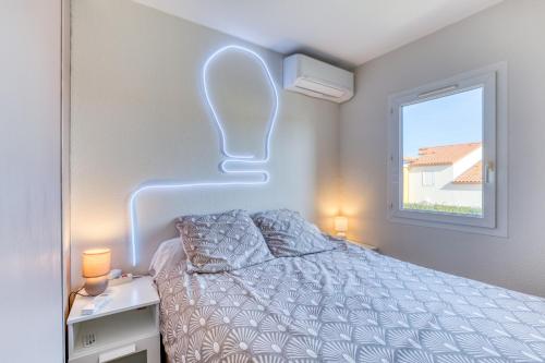 a bedroom with a bed and a window with lights at Le Mas de la Mer in Frontignan