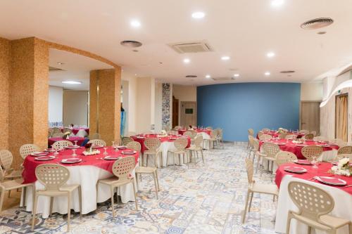 a banquet hall with red and white tables and chairs at Albergo Athenaeum in Palermo
