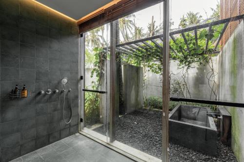 La salle de bains est pourvue d'une douche et d'un lavabo. dans l'établissement Rumah Amadangi, à Tanah Lot