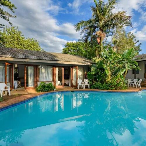 a swimming pool in front of a house at HLULALA GUEST HOUSE in Hluhluwe