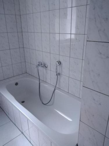 a white bath tub with a hose in a bathroom at NEU! See-Ferienwohnung 4 in Großmöhlau