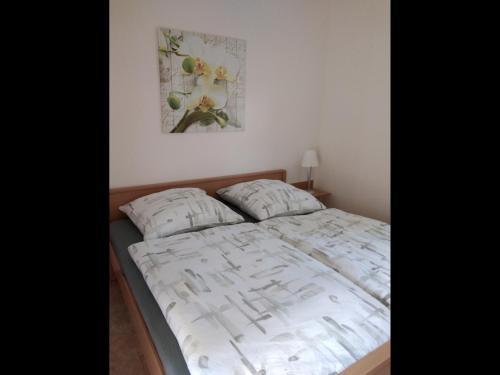 uma cama num quarto com uma fotografia na parede em NEU! See-Ferienwohnung 2 em Großmöhlau