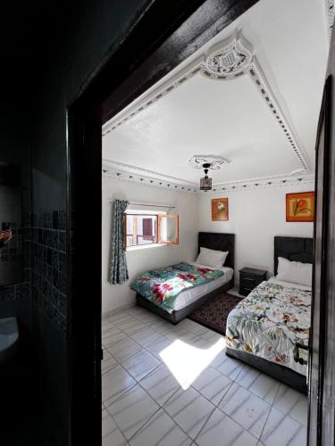 a bedroom with two beds and a window at Riad Palais D'Or in Rabat