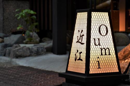 um sinal iluminado com a palavra aberta numa mesa em Guest House Oumi em Quioto