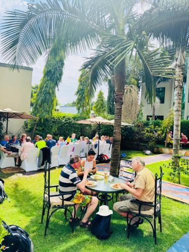 a group of people sitting at a table in the grass at Green Mountain Hotel in Arusha