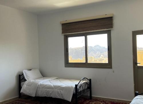 1 dormitorio con cama y ventana en Eman house, en Wadi Musa