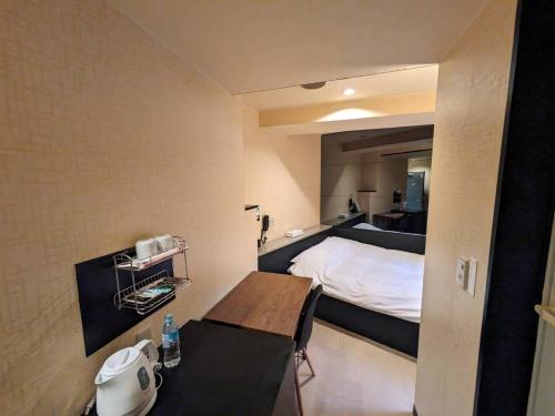 Postel nebo postele na pokoji v ubytování ラグナイン 八王子 Laguna inn