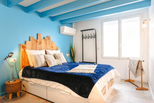 ein Schlafzimmer mit einem großen Bett mit blauer Decke in der Unterkunft chez Frederique in Saint-Trojan-les-Bains