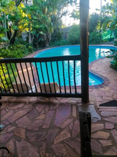 a bench in front of a swimming pool at HLULALA GUEST HOUSE in Hluhluwe