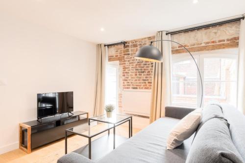 un salon avec un canapé et une télévision dans l'établissement Old Lille - Lovely typical apartment!, à Lille