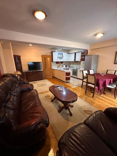 a living room with a leather couch and a table at cvetkovski apartment in Tetovo