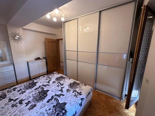 een slaapkamer met een bed en een glazen schuifdeur bij cvetkovski apartment in Tetovo