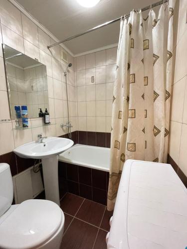 łazienka z toaletą, umywalką i wanną w obiekcie Изумруд w mieście Pietropawłowsk Kamczacki