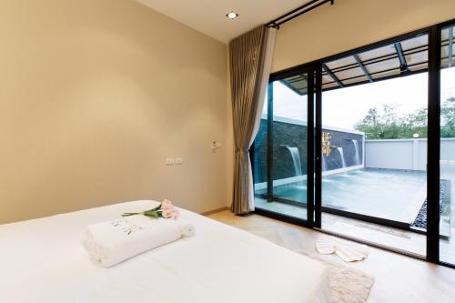 a bedroom with a bed and a large window at Nue Hatyai Pool Villa 147 in Songkhla