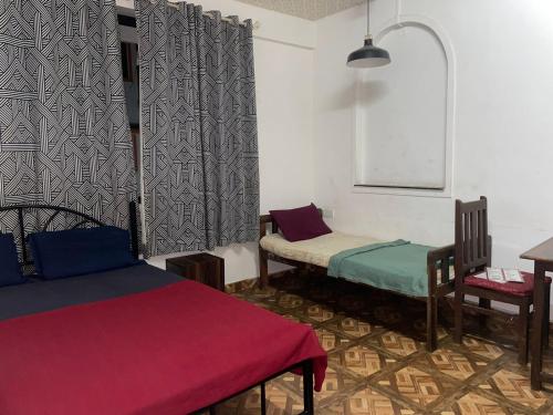 Zimmer mit 2 Betten, einem Tisch und Stühlen in der Unterkunft Pihuu hotel in Calangute