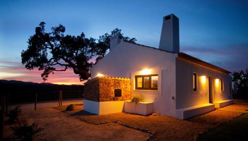 a house with lights on the side of it at night at Sernadinha in Aldeia do Cano