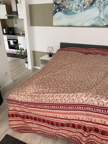 Un dormitorio con una cama con una manta. en Ferienwohnung mit Blick auf den Feldberg, en Weilmünster
