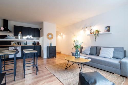 un salon et une cuisine avec un canapé et une table dans l'établissement Lille Grand Place - 1 bedroom apartment, à Lille