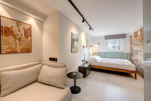 ein Wohnzimmer mit einem Sofa und einem Bett in der Unterkunft DR Apartments - Cape in Sopot