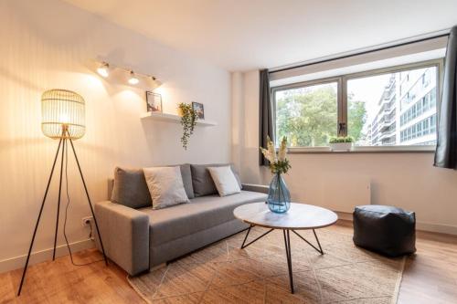 un salon avec un canapé et une table dans l'établissement Lille Grand Place - 1 bedroom apartment, à Lille